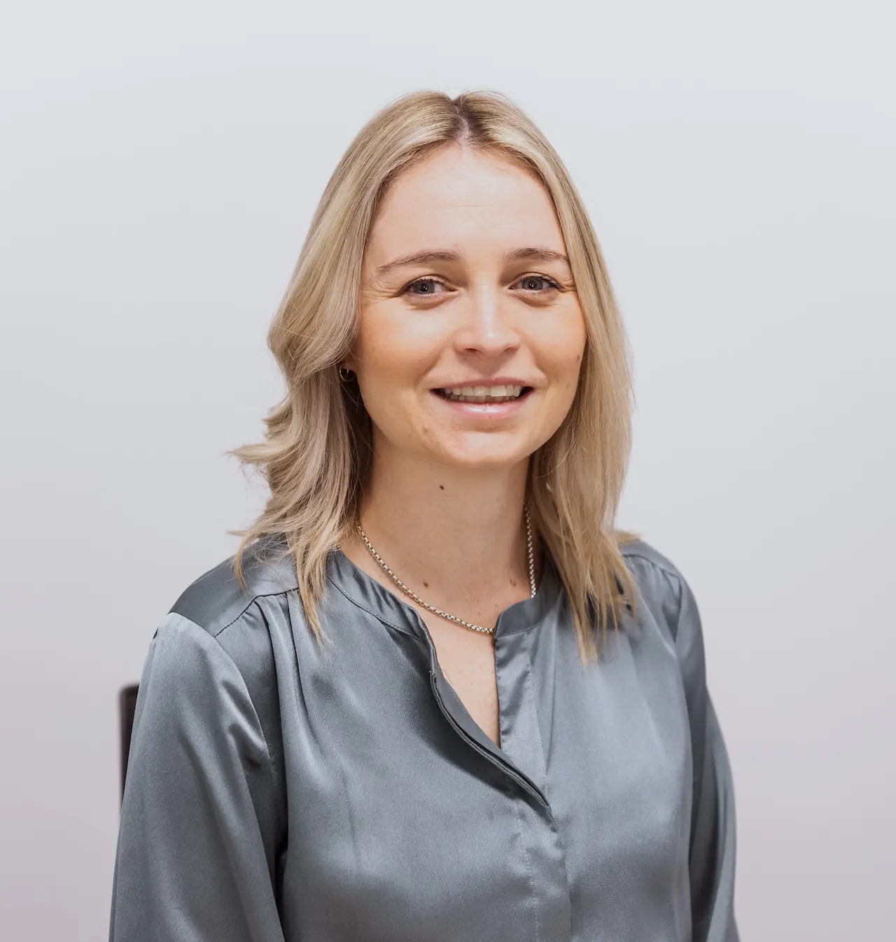 Megan Porter smiling at camera in portrait photoshoot.